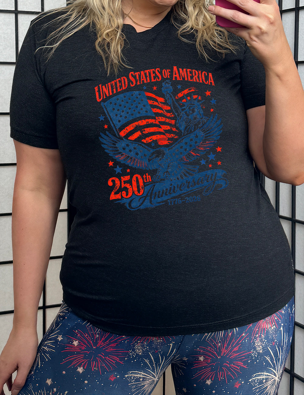 black unisex tee with the graphic of the eagle, wings spread, the statue of liberty, and an American flag, and lots of little stars, and the words saying "United Stated of America 250th Anniversary 1776-2026"