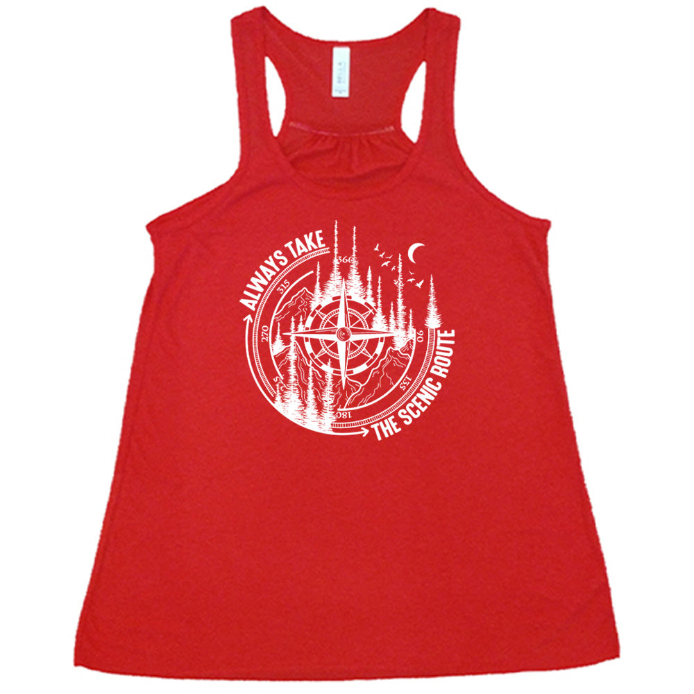 Red colored flowy tank with a compass and forest graphic on it that says "Always Take The Scenic Route"