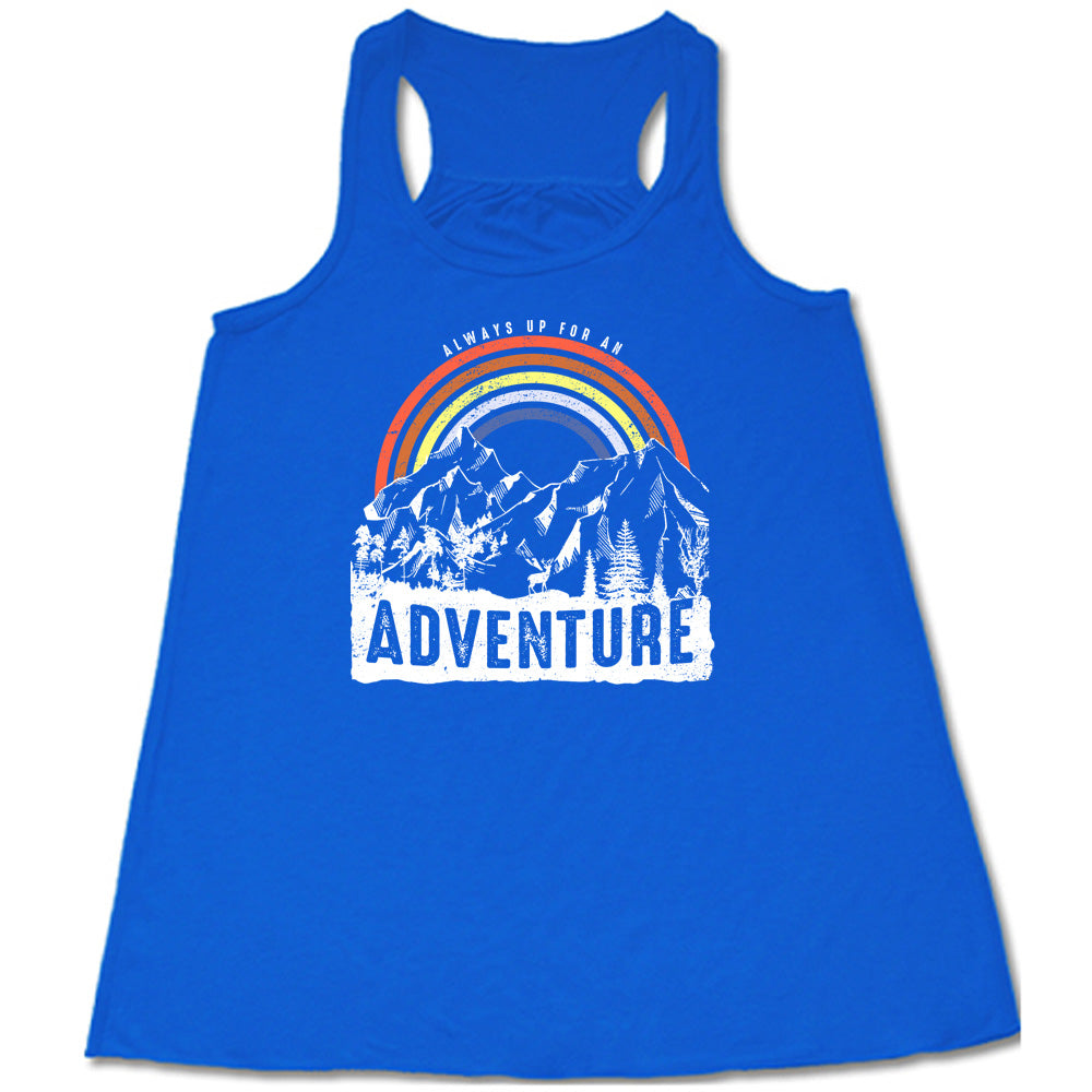 Blue colored flowy tank with a rainbow over mountains graphic on it that says "Always Up For An Adventure"