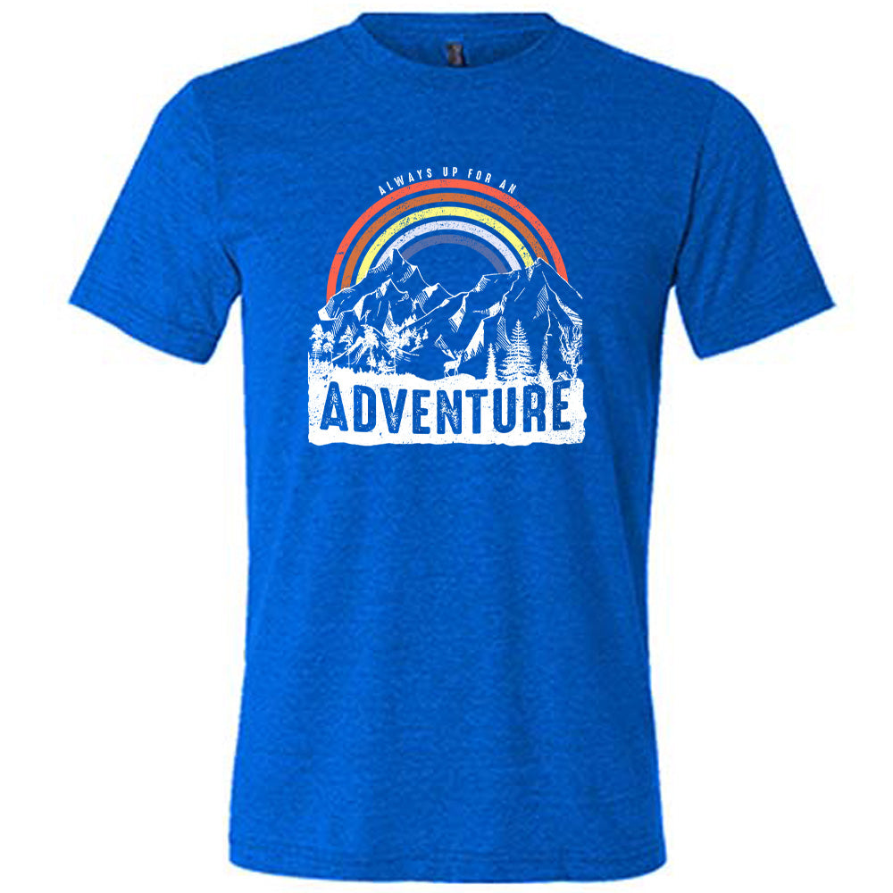 Blue colored shirt with a rainbow over mountains graphic on it that says "Always Up For An Adventure"