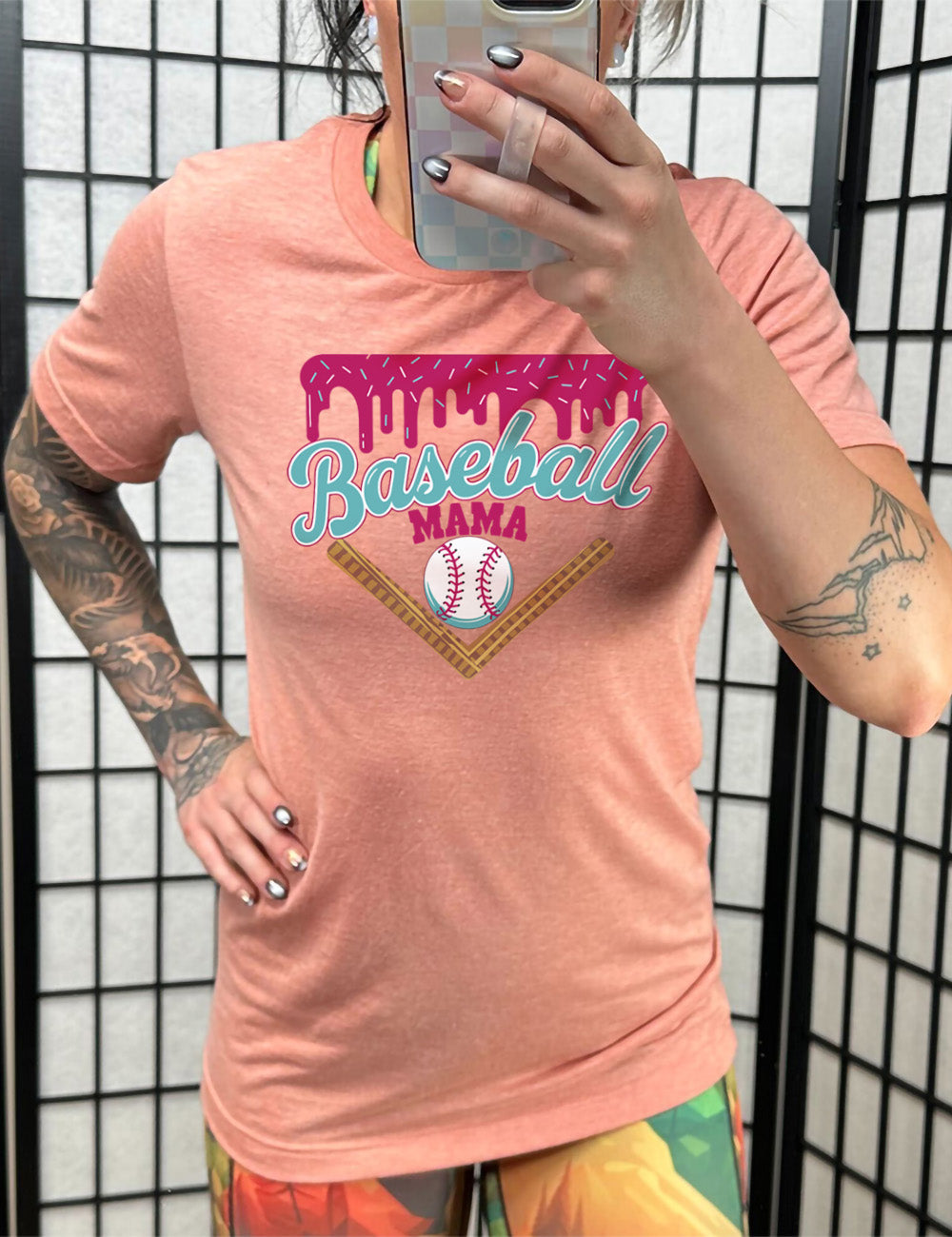 sunset unisex tee with the words "baseball mama" on it, with a border with sprinkles above the words, dripping down, and a baseball underneath the words, and a border in a V below everything