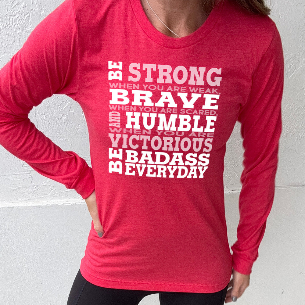 heather red long sleeve with the words "Be STRONG when you are weak, BRAVE when you are scared, and HUMBLE when you are victorious be badass everyday" in white lettering
