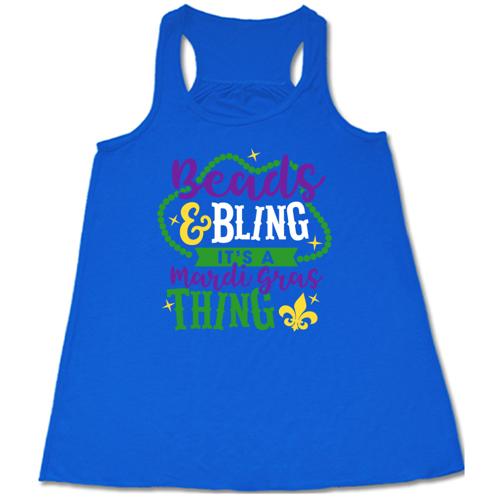 blue flowy tank with the words "beads & bling it's a mardi gras thing" on it, with graphics of a ring of beads around part of the words and a few stars as well as a fleur-de-lis symbol