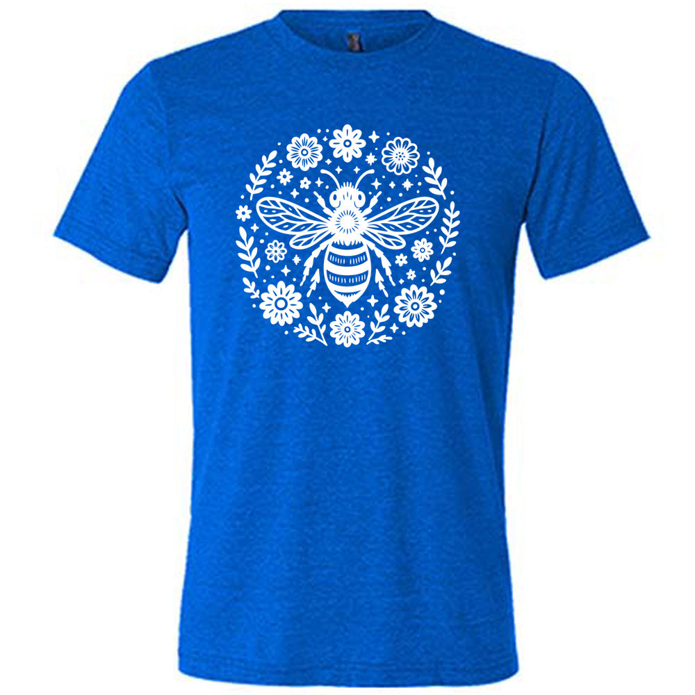 blue unisex tee with the graphic of a boho circled design filled with flowers of varied size, some branches, some stars, and in the center a fancy bee