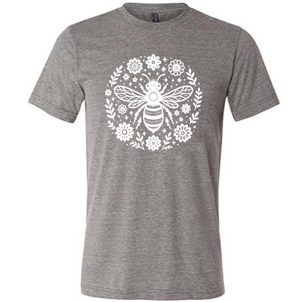 grey unisex tee with the graphic of a boho circled design filled with flowers of varied size, some branches, some stars, and in the center a fancy bee