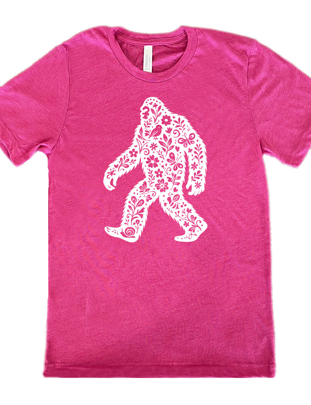 berry unisex tee with the graphic white cutout of bigfoot, which is overlayed with black flowers, plants, birds, bees, snails, and butterflies