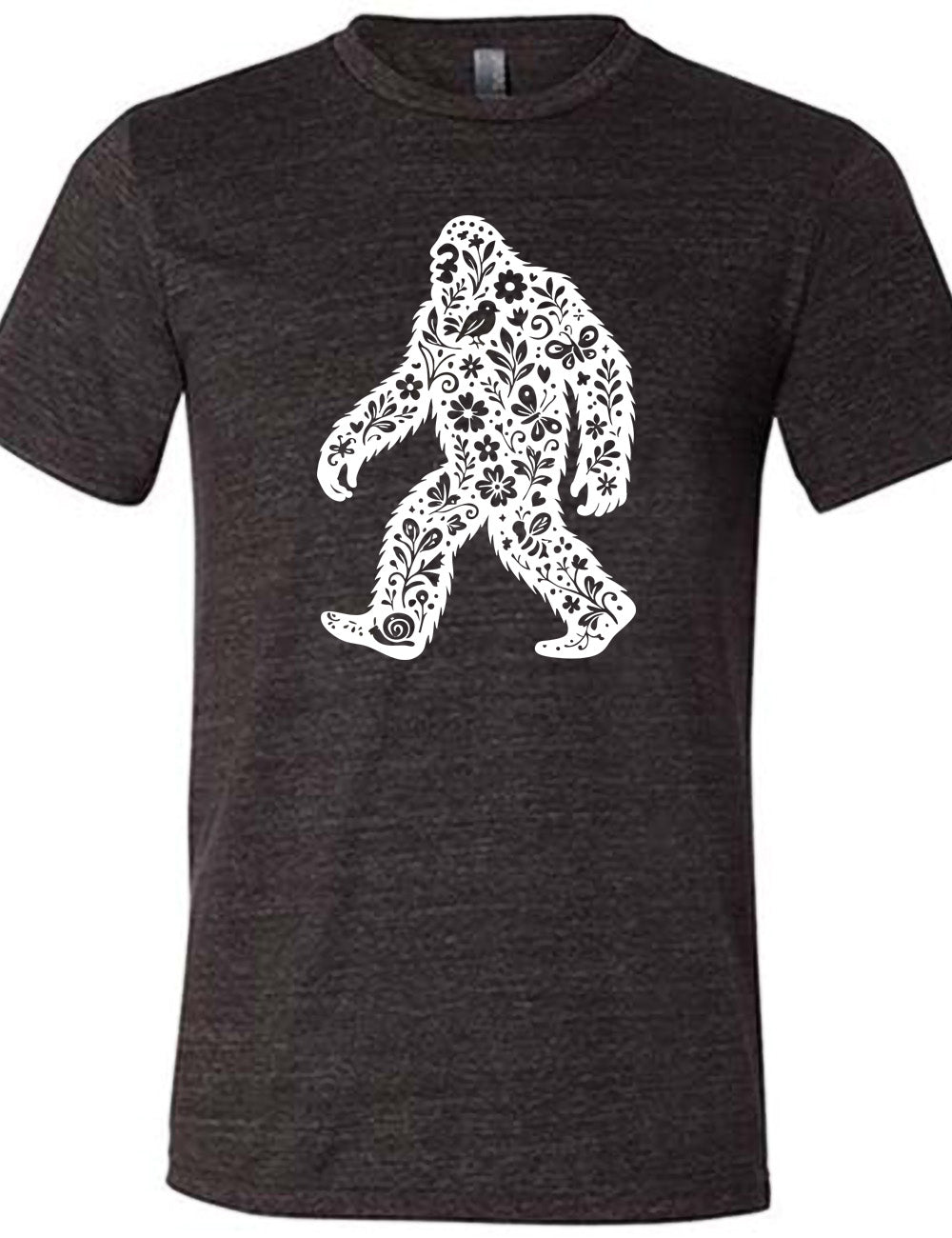 black unisex tee with the graphic white cutout of bigfoot, which is overlayed with black flowers, plants, birds, bees, snails, and butterflies