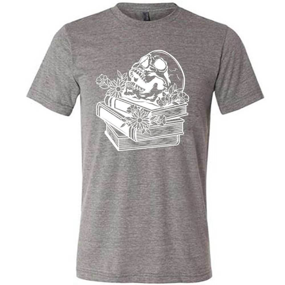 grey unisex tee with the graphic of an open-mouthed skull atop a stack of books, with flowers
