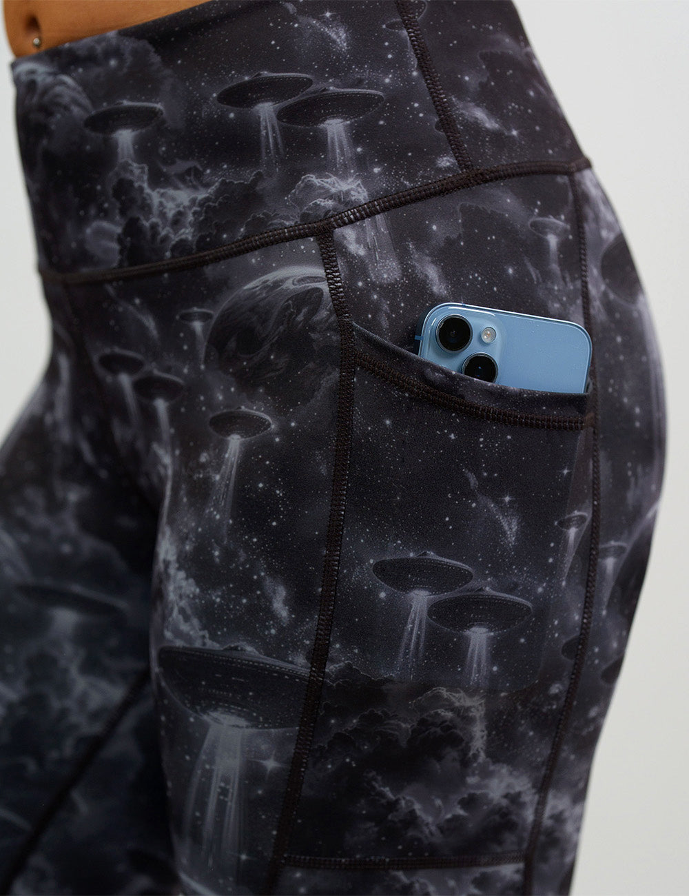 close up of the alien space ship invasion leggings with a phone in its pocket