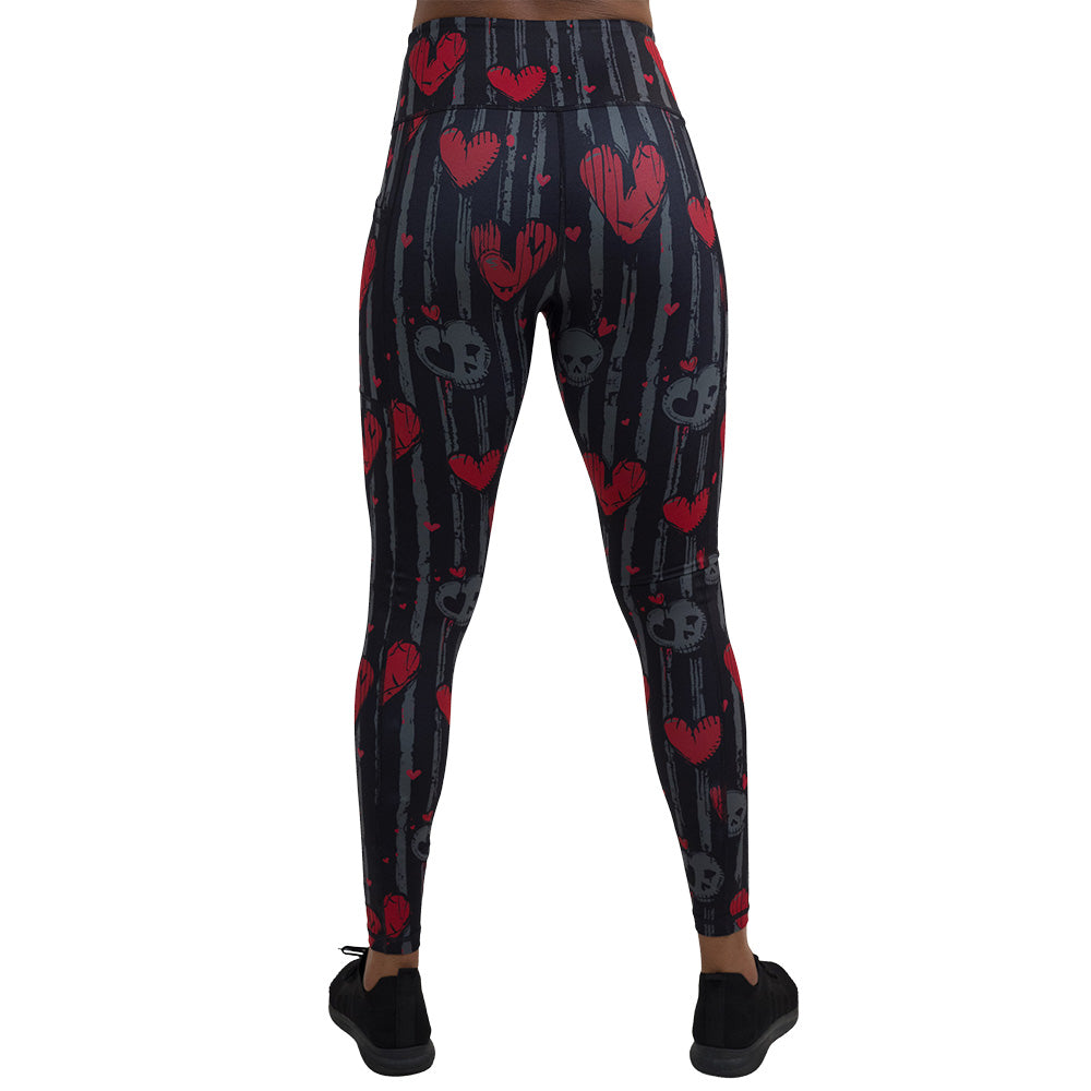 back of the red heart and gray skulls against a black and grey striped background full length leggings against a white background
