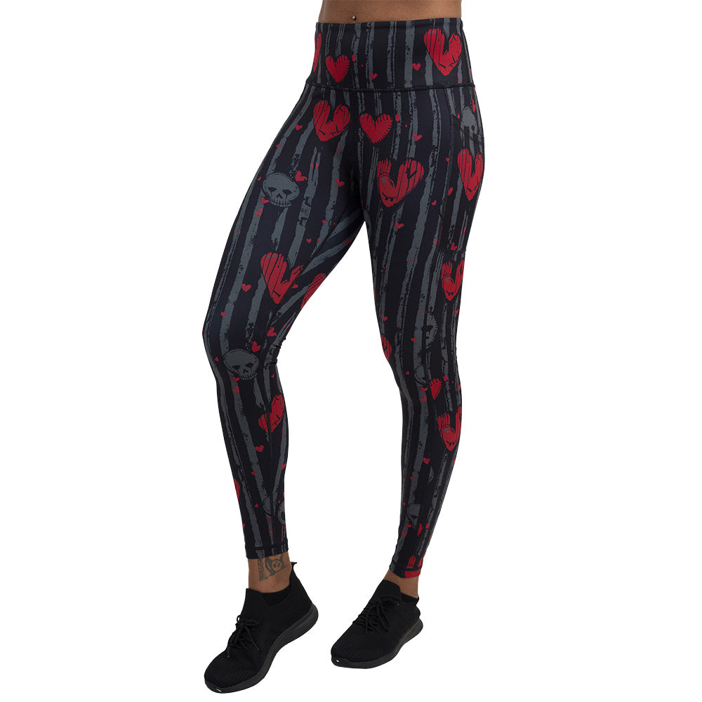 red heart and gray skulls against a black and grey striped background full length leggings facing the front against a white background