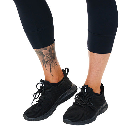 close up of the cuffed detailing on the solid black leggings against a white background