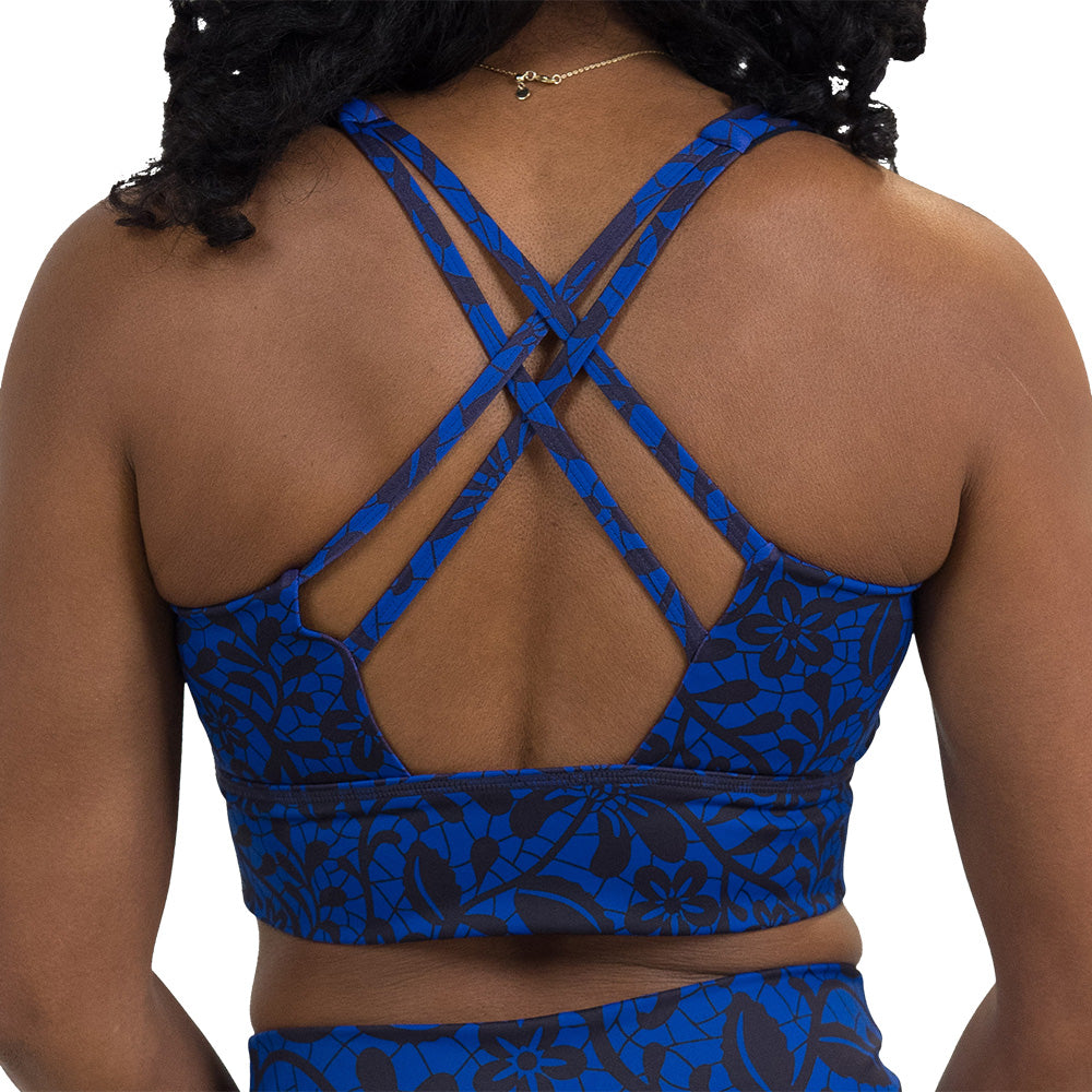 back of the black floral against a dark blue background longline bra against a white background