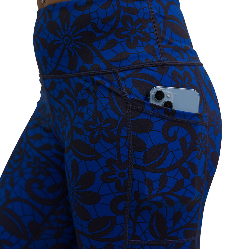 close up of the black floral against a dark blue background leggings with a phone in the pocket