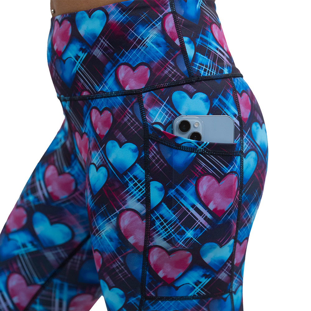close up of the blue and pink hearts pattern against a dark stitched background leggings