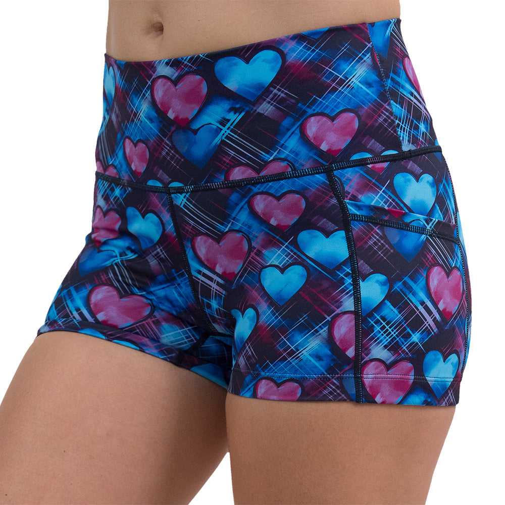close up of the 2.5 inch blue and pink hearts pattern against a dark stitched background shorts against a white background