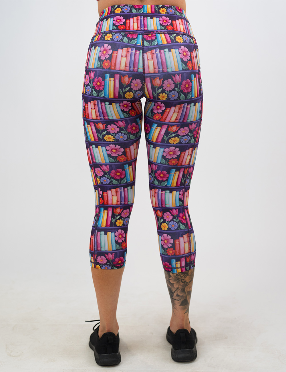 back of the brightly colored books and flowers capri leggings against a white background