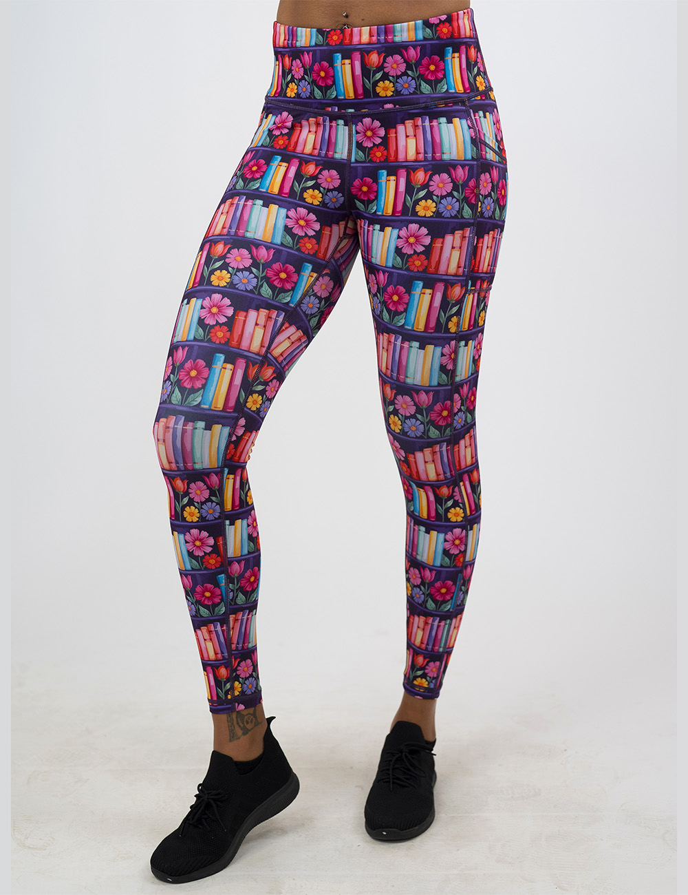 brightly colored books and flowers full length leggings facing the front against a white background