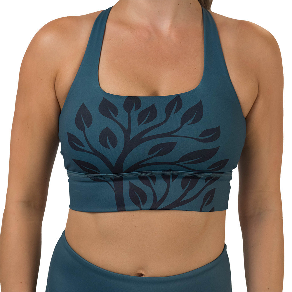 Teal sports bra with black leaf pattern on a white background