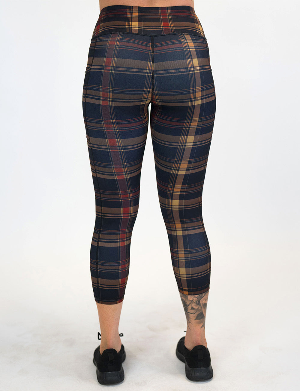 back of the capri red, black, and gold plaid leggings against a white background