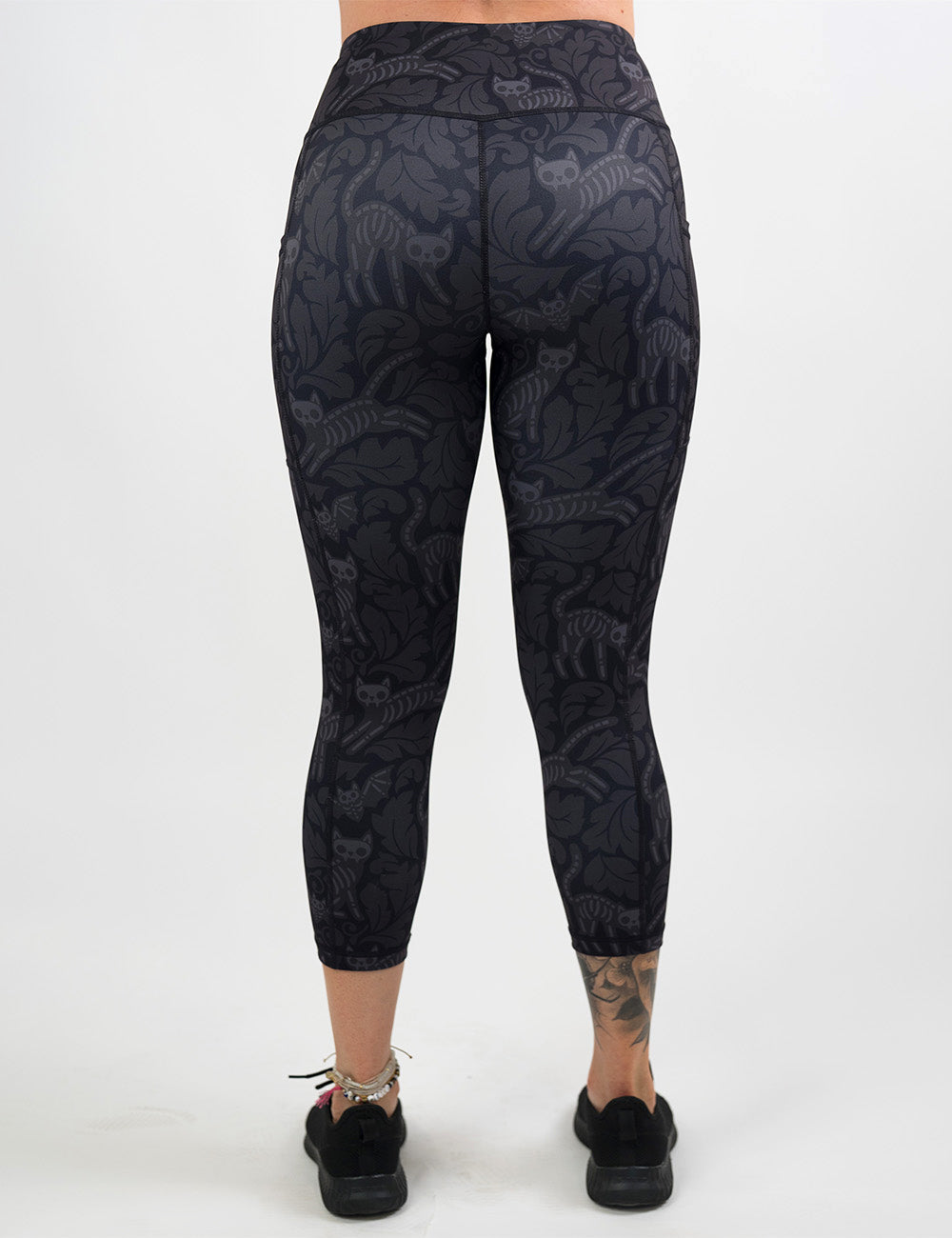 back of the black and grey bats and cats skeletons capri leggings against a white background