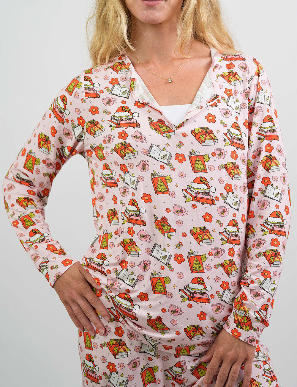 front of the Christmas books and flowers all over pink pajama top against a white background
