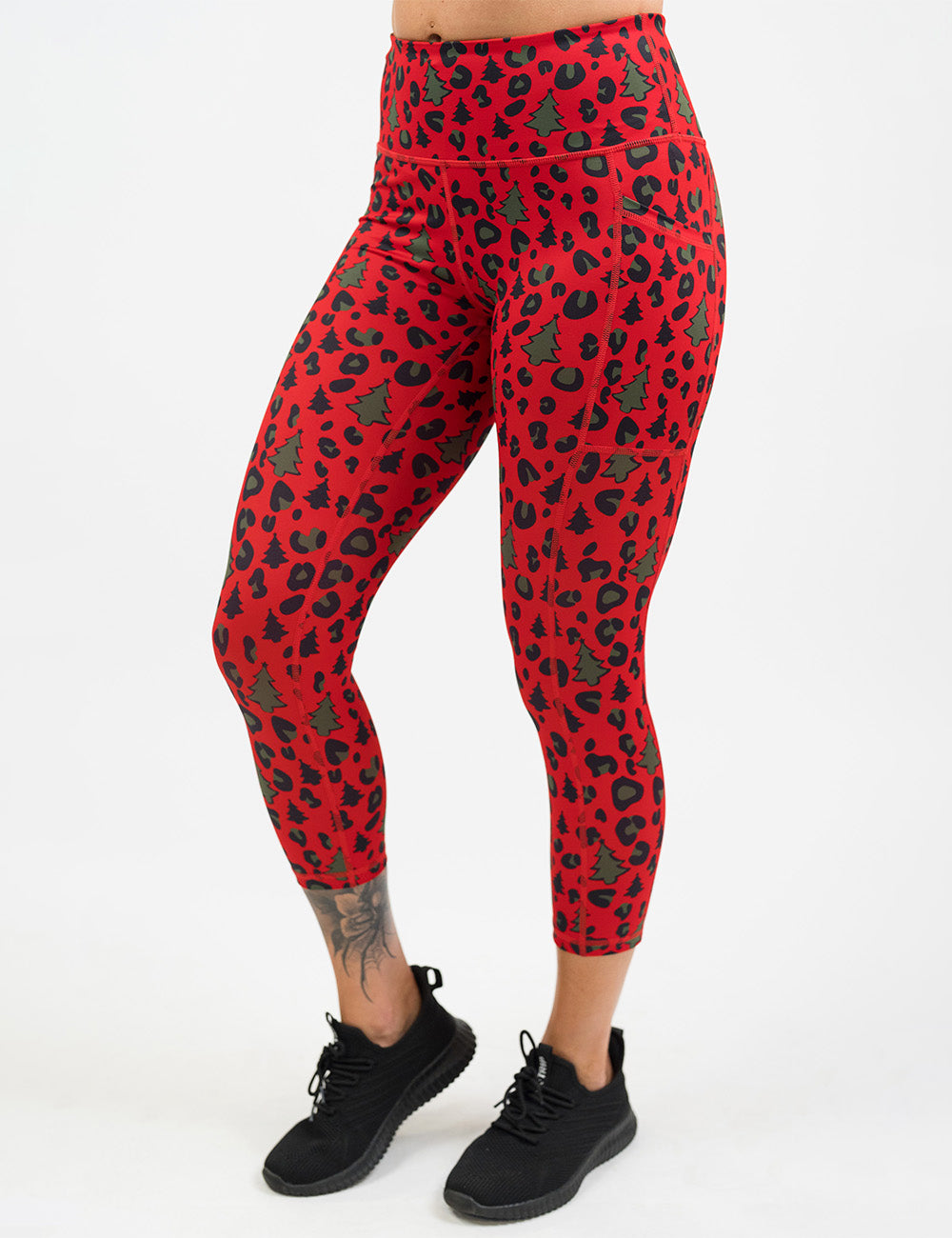 front of the red and brown Christmas trees and leopard print capri leggings against a white background