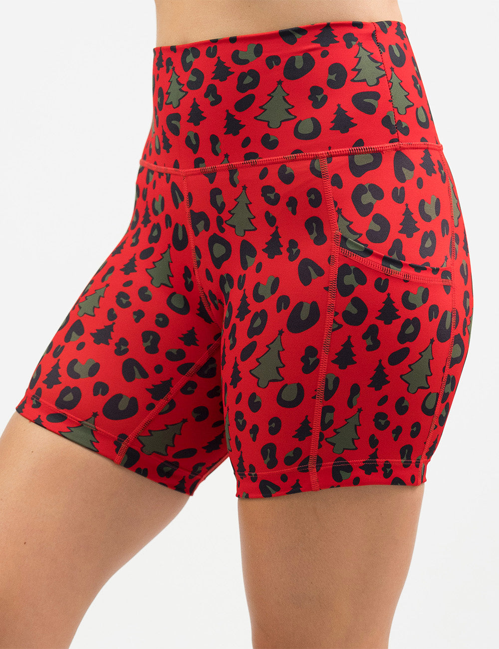 front of the red and brown Christmas trees and leopard print 5 inch shorts against a white background