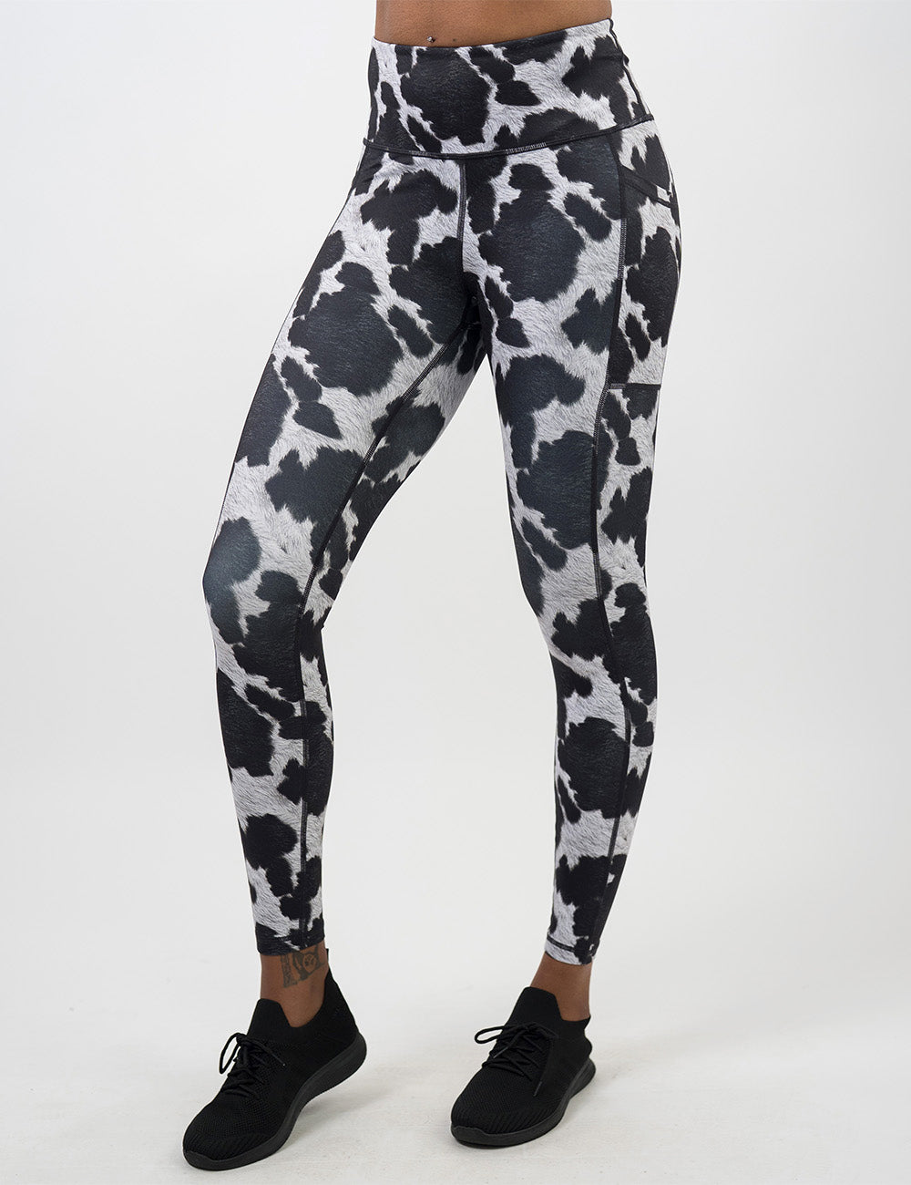 front of the full length cow print leggings against a white background