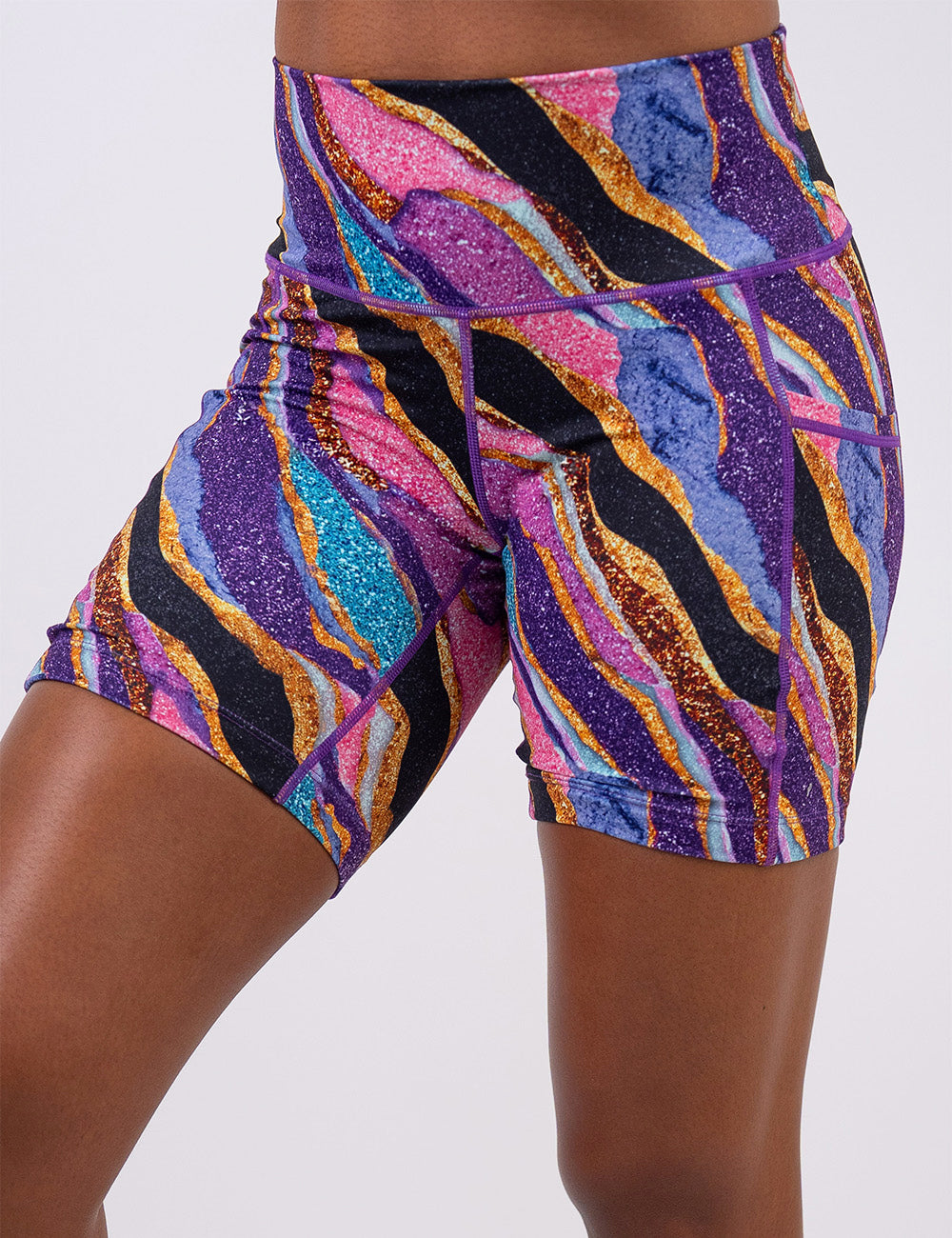 front of the 7 inch purple, gold, black, blue, and pink abstract stripes shorts against a white background