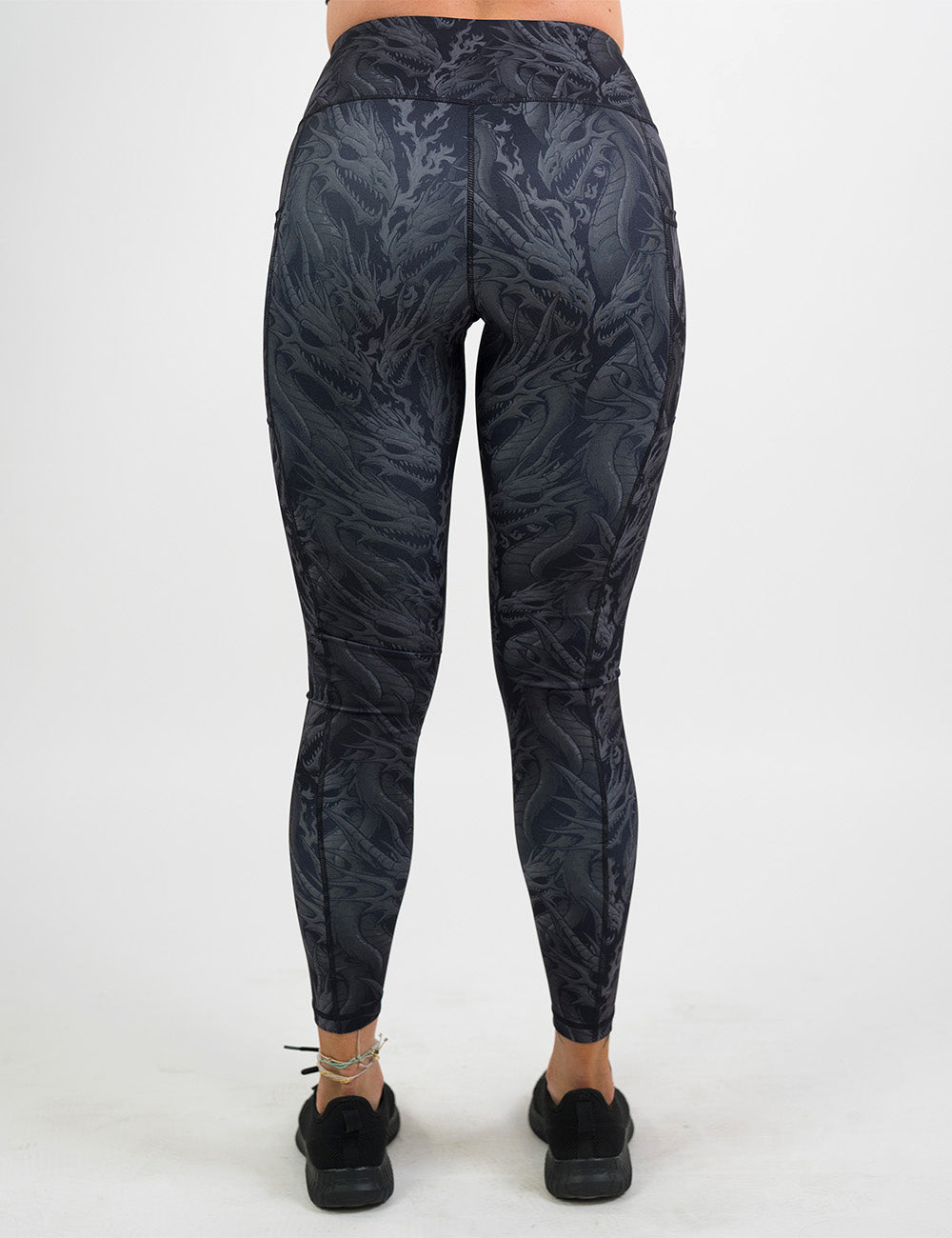 back of the full length black leggings with grey dragons against a white background