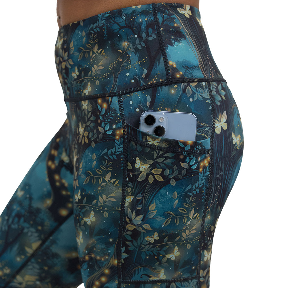close up of the forest filled with firefly's pattern leggings pocket holding a phone against a white background