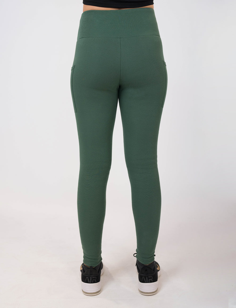 back of the dark green fleece lined leggings against a white background
