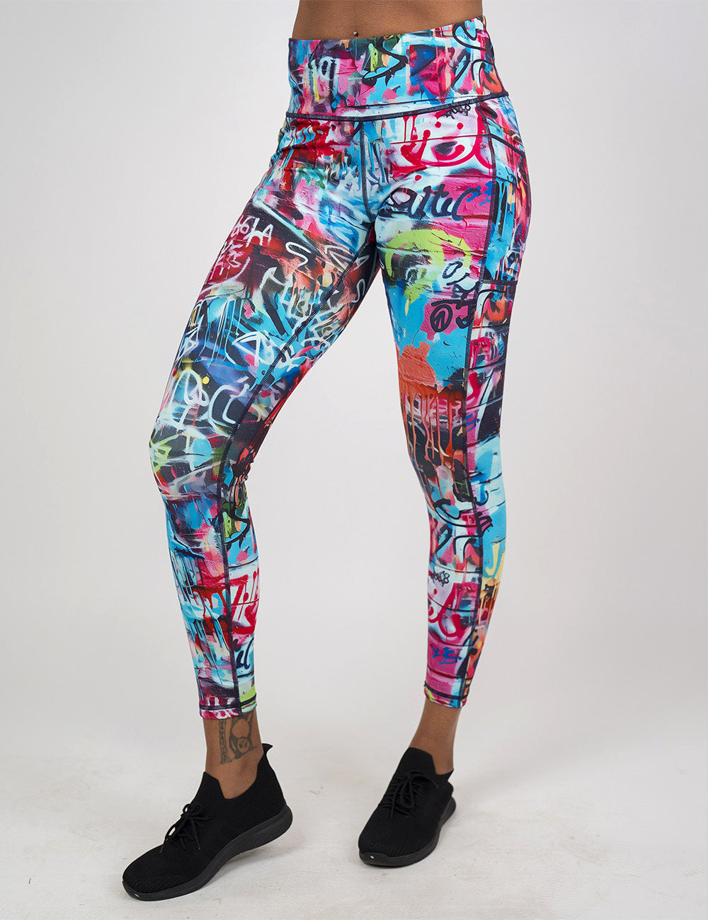 front of the full length multi colored graffiti covered leggings against a white background