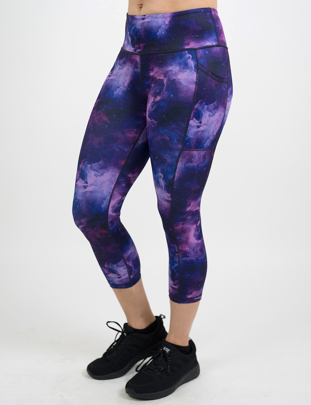 front of the purple space patterned capri leggings against a white background