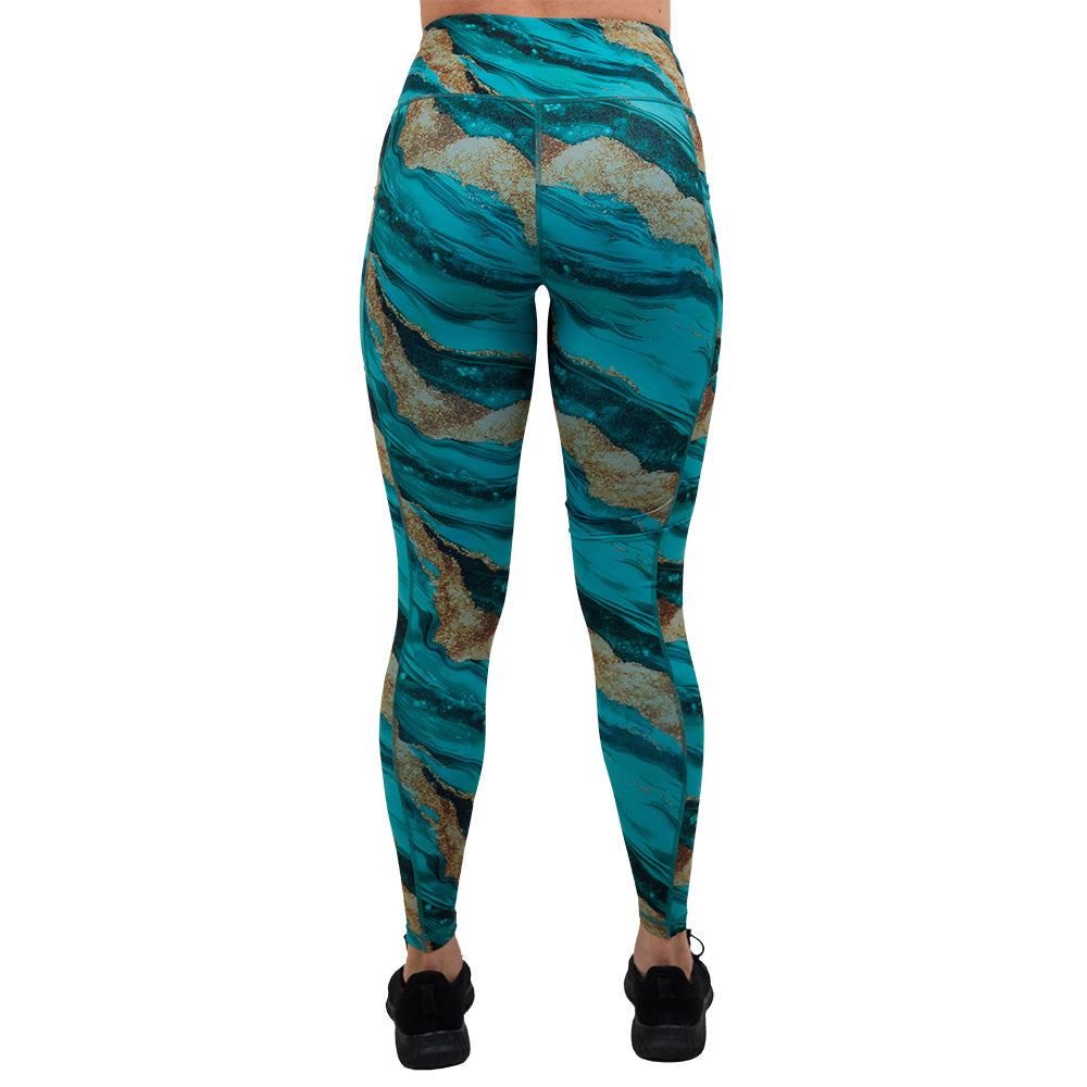 back of the blue ocean with gold streaks patterned full length leggings against a white background