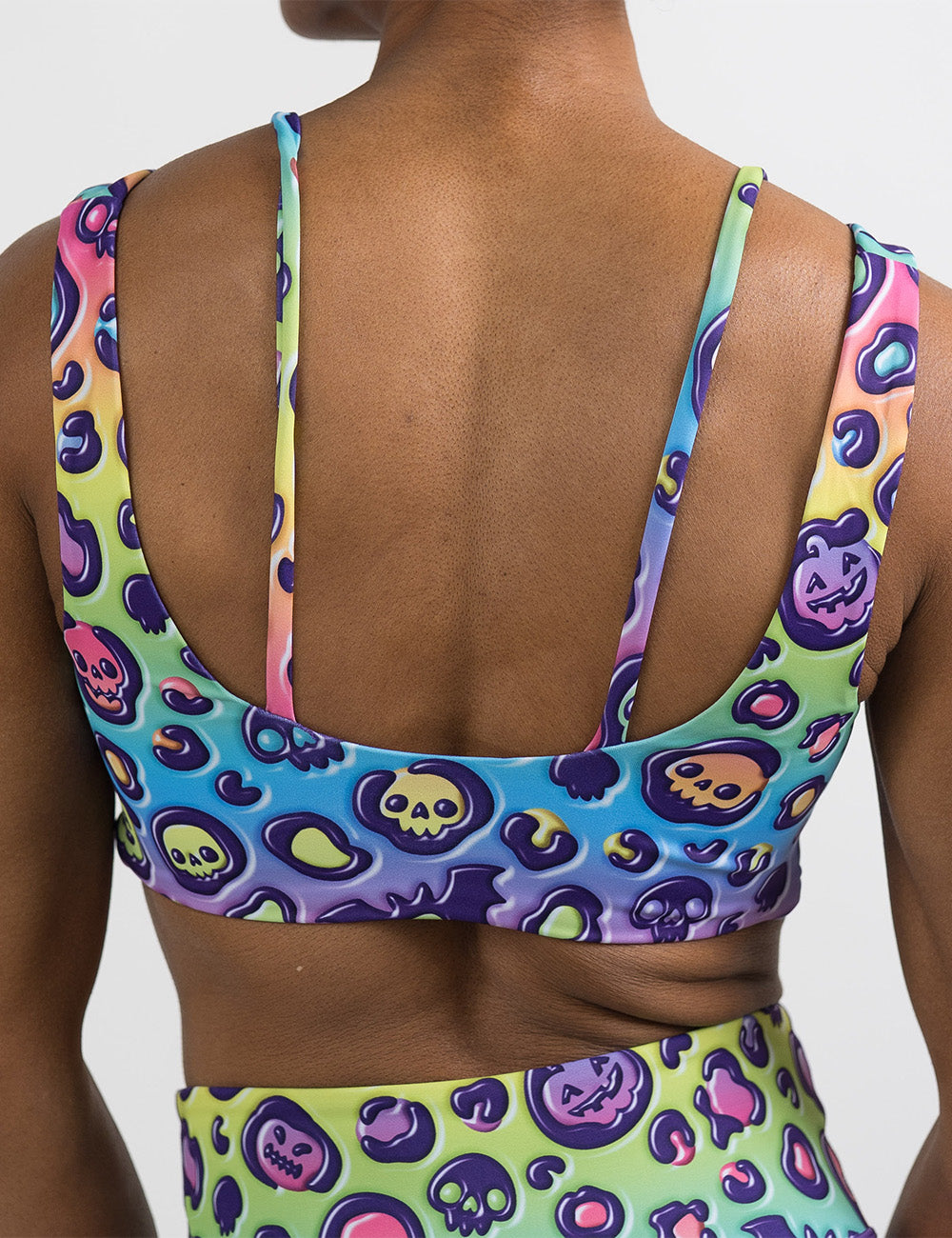 back of the rainbow leopard print pumpkins and skulls bra against a white background