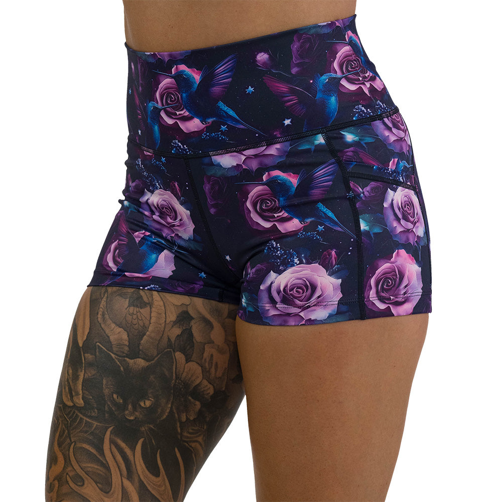 shorts with a design of a blue hummingbird and pink roses