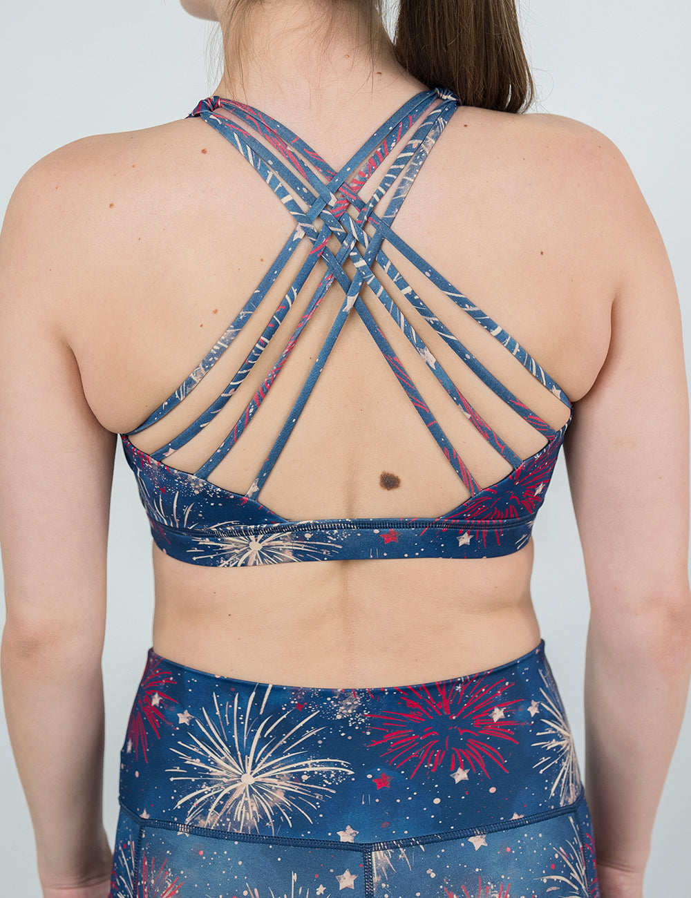 back of the red and white fireworks against a blue background pattern butterfly back bra against a white background