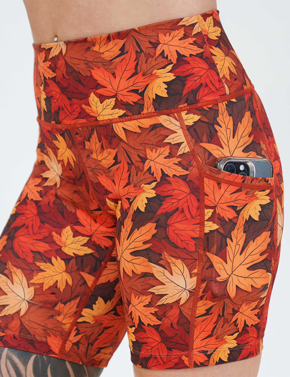 close up of the 7 inch orange leaves shorts with a phone in its pocket