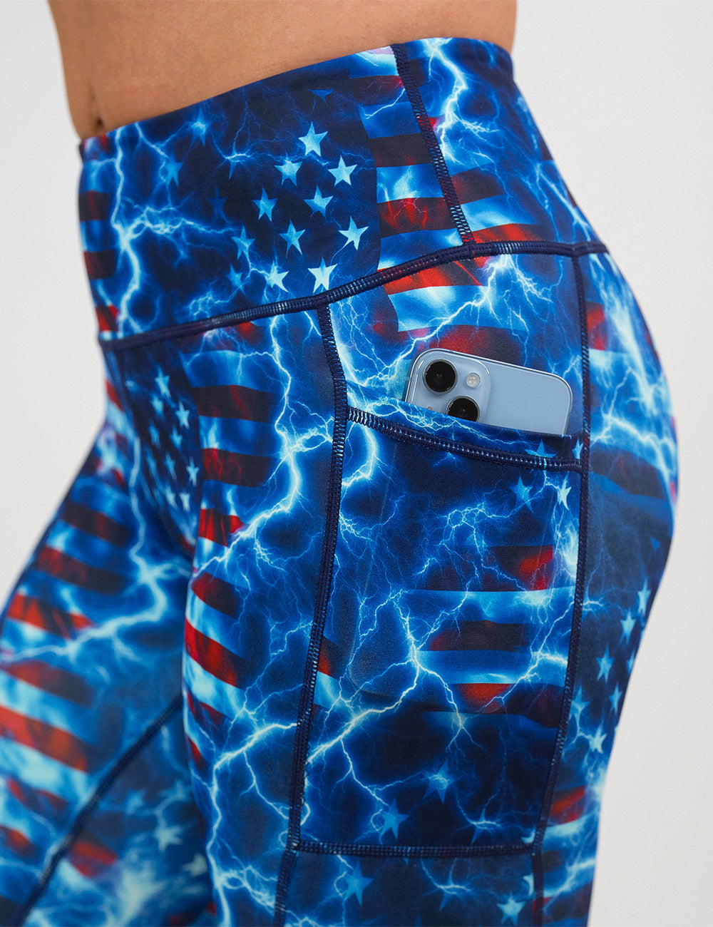 close up of the lightning flag leggings holding a phone in its pocket