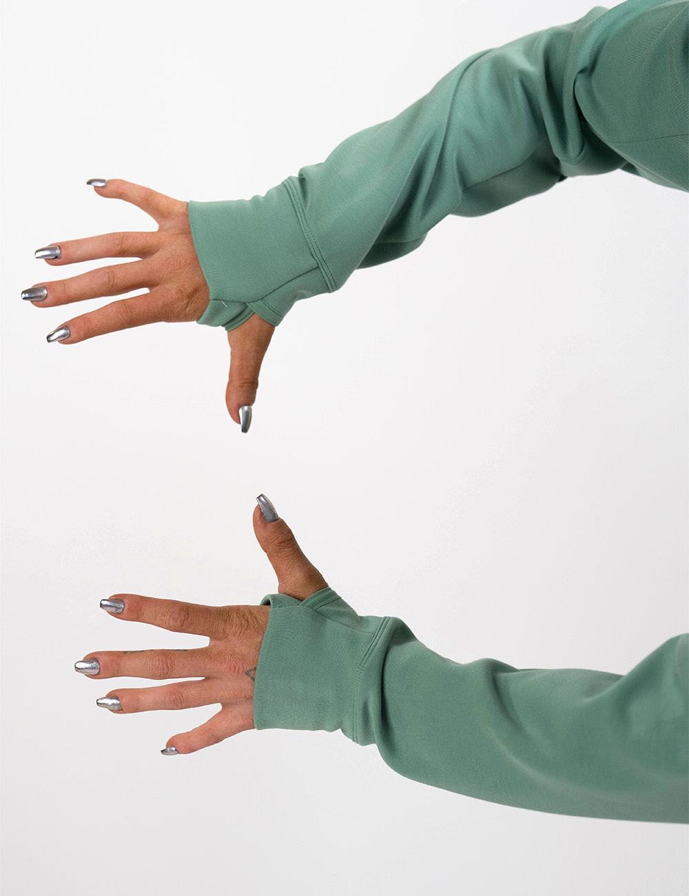 close up of the light green hoodies showing the thumb hole cuffs against a white background