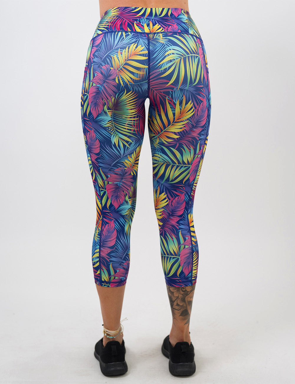 back of the capri vibrant rainforest leaves leggings against a white background