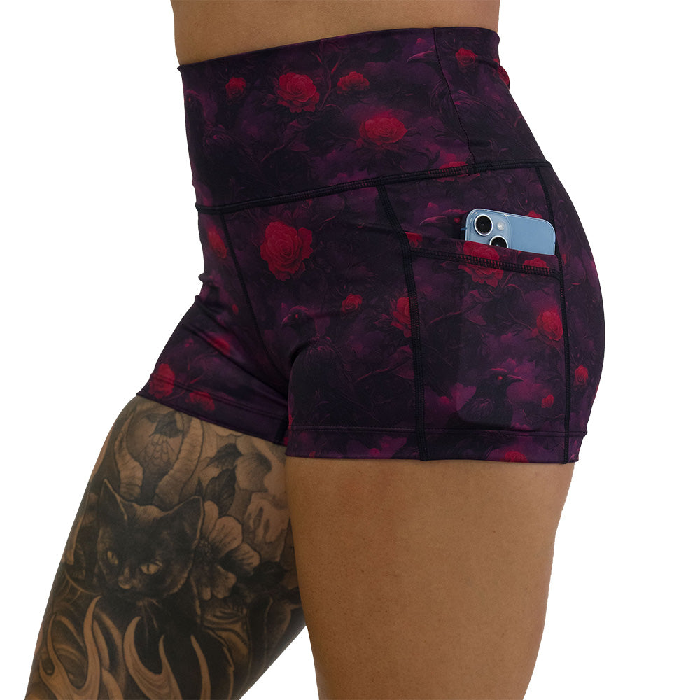 Black shorts with red floral and crow pattern on it