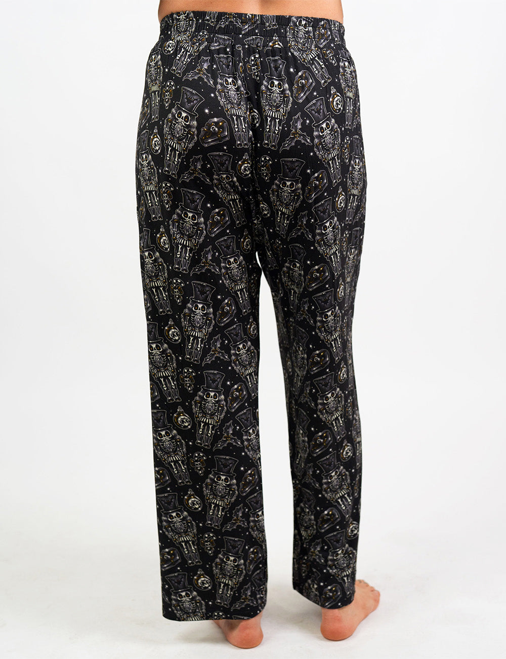 back of the black nutcrackers, mistle toe, and Christmas ornaments pajama bottoms against a white background