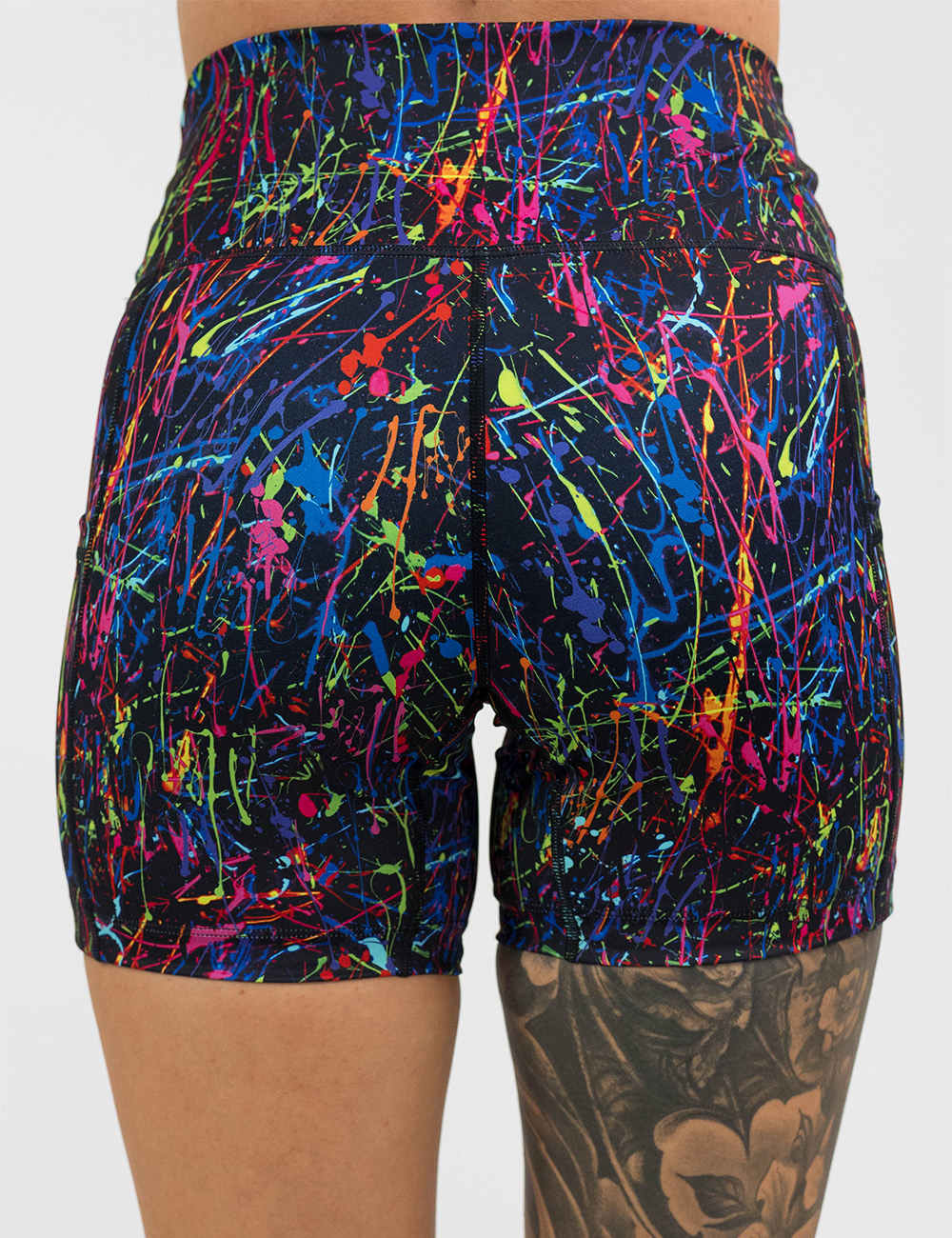 back of the 5 inch rainbow paint splatter against a black background shorts against a white background