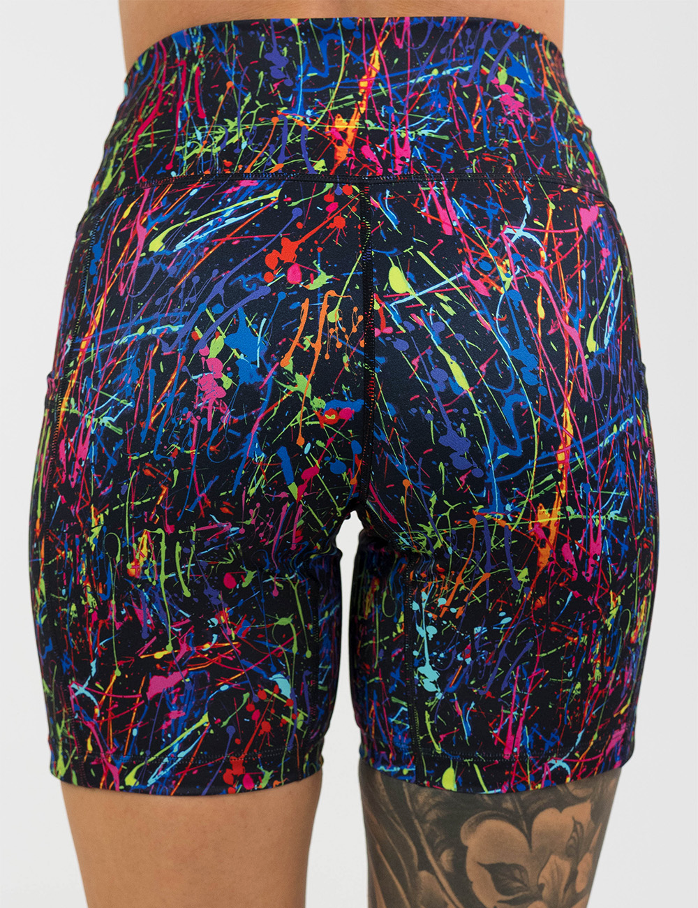back of the 7 inch rainbow paint splatter against a black background shorts against a white background