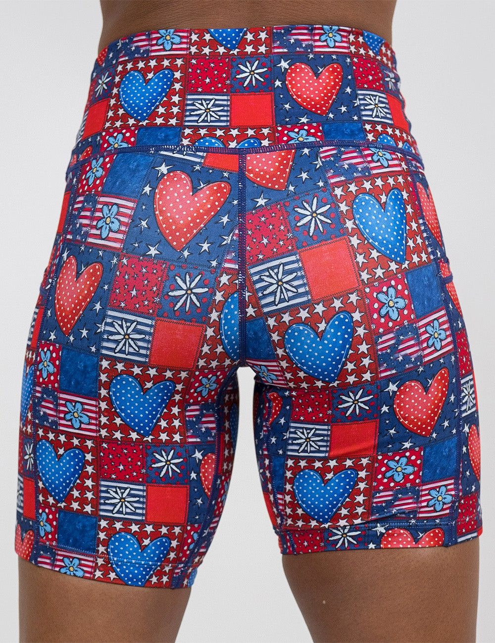 back of the 7 inch patchwork american flag with red and blue hearts pattern shorts against a white background