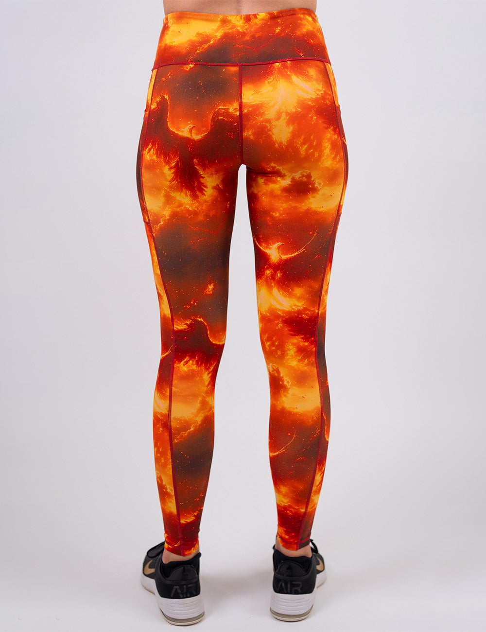 back of the phoenix surrounded by fire full length leggings against a white background