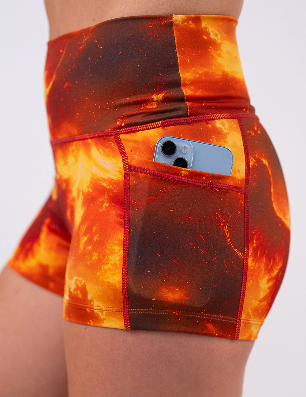 close up of the 2.5 inch phoenix surrounded by fire shorts with a phone in its pocket